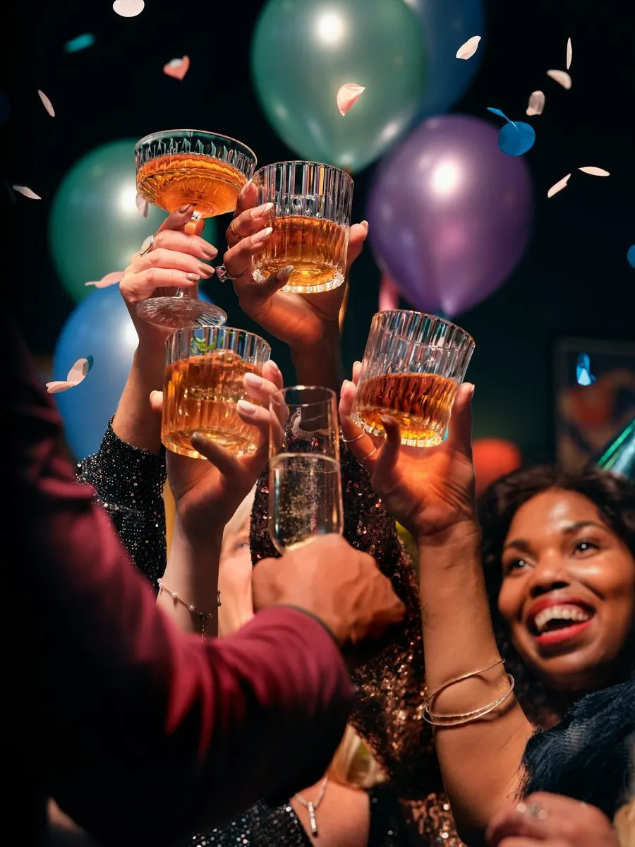 Friends raise their glasses under confetti