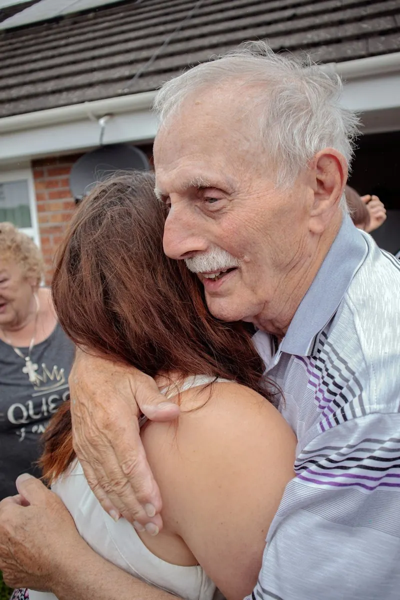 Un grand-père serre une jeune femme dans ses bras