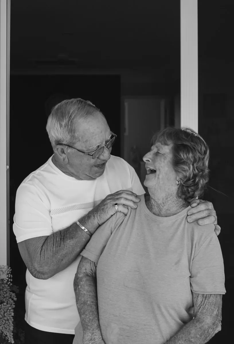 Un couple de grands-parents qui rient, en noir et blanc