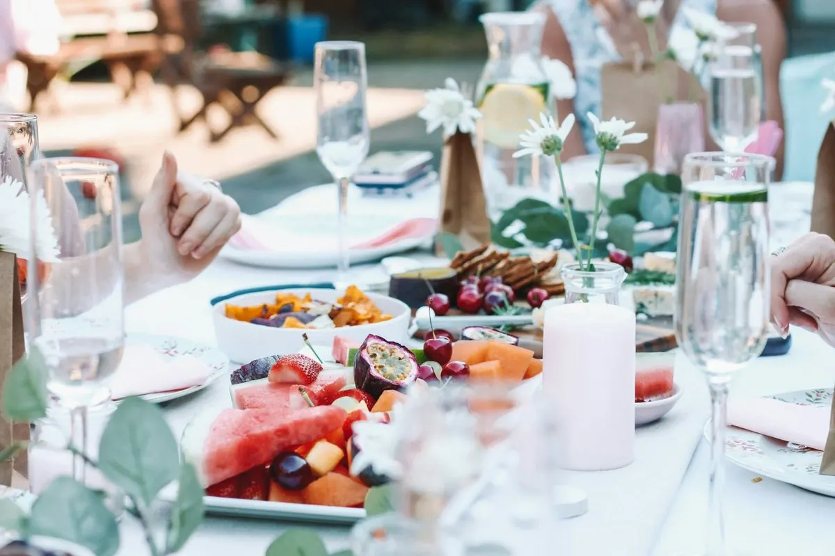 Une table d'apéritif dressée au jardin, flûtes et fruits frais