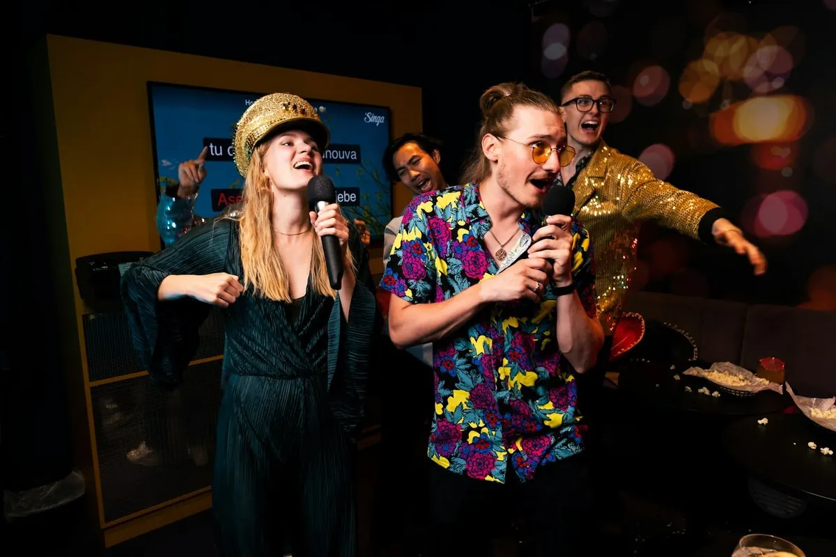 Une bande chante à pleine voix sur la scène d'un karaoké