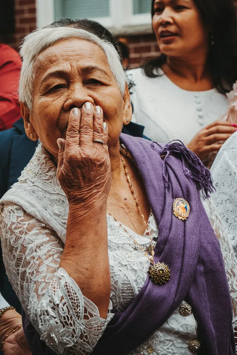 Une grand-mère qui rit, la main devant la bouche