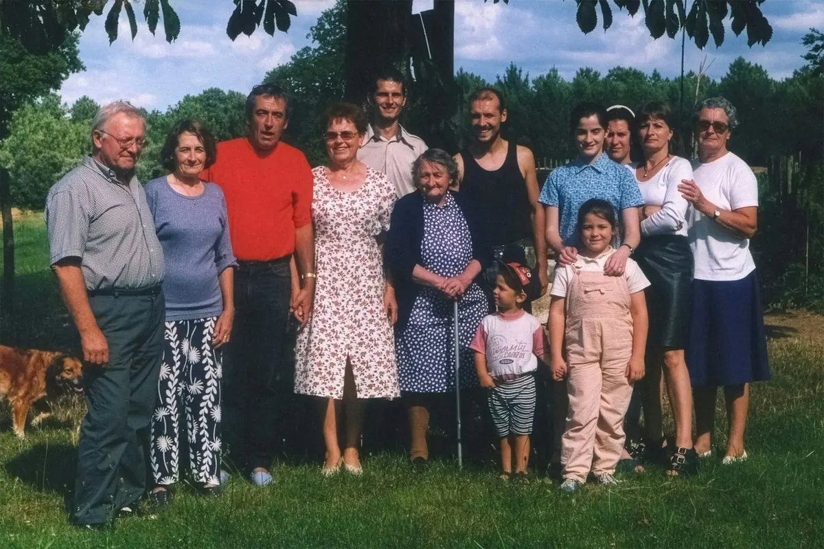 Une grande famille pose dans un jardin pour la photo de groupe