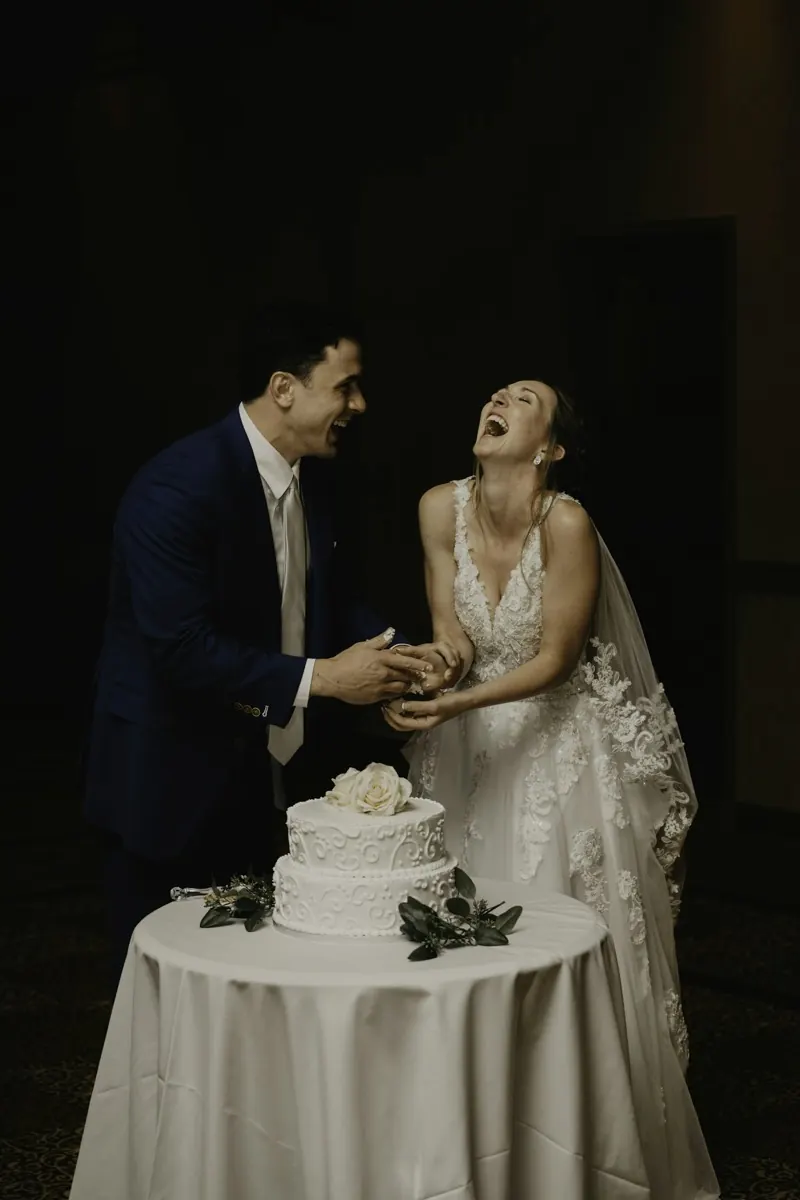 Les mariés éclatent de rire en coupant leur gâteau