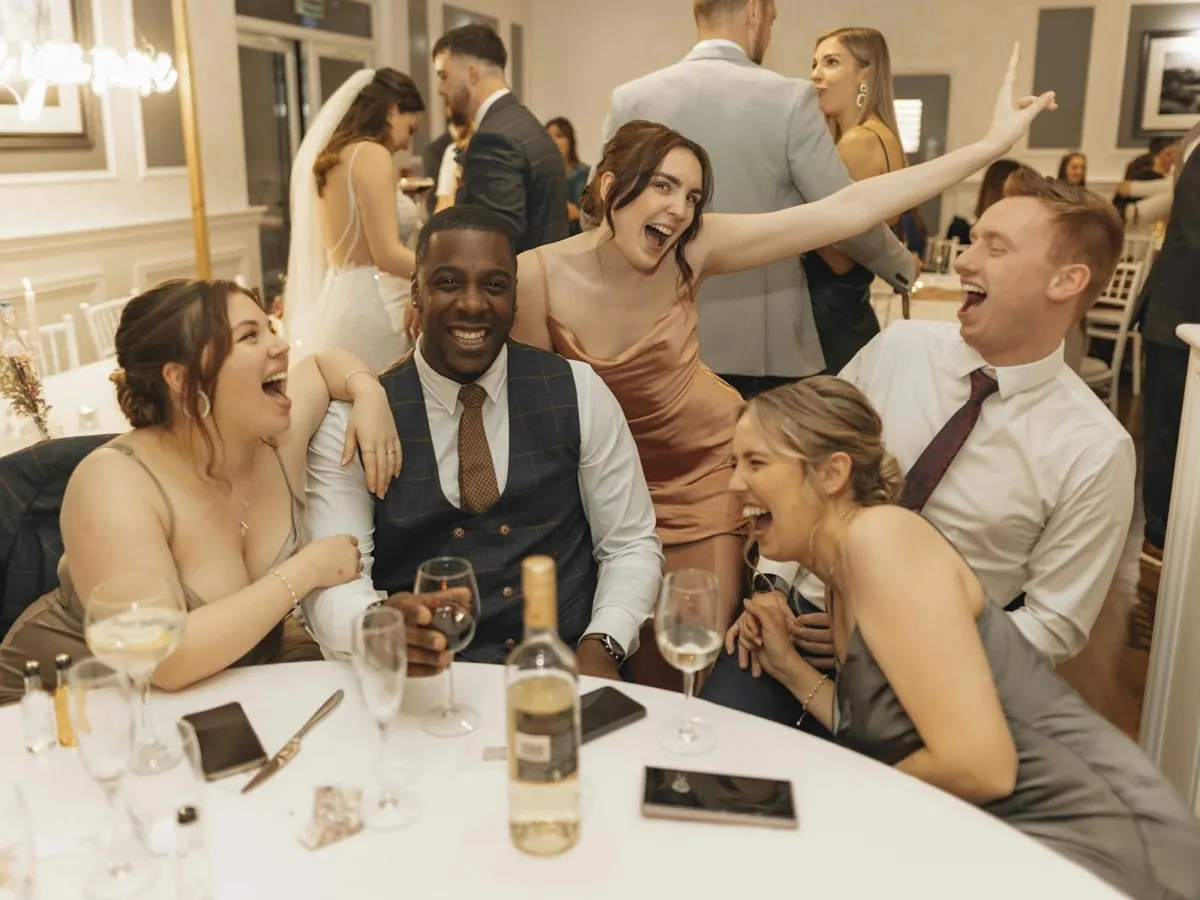 Une tablée d'invités en plein fou rire pendant le dîner