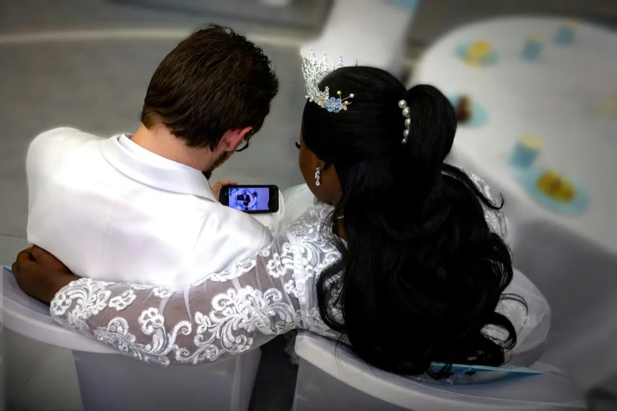 Des mariés regardent ensemble l'écran d'un téléphone